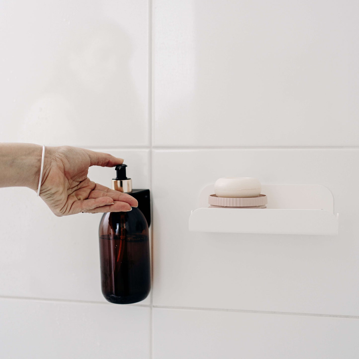 etagere noir en metal pour poser une bouteille de savon de mamik