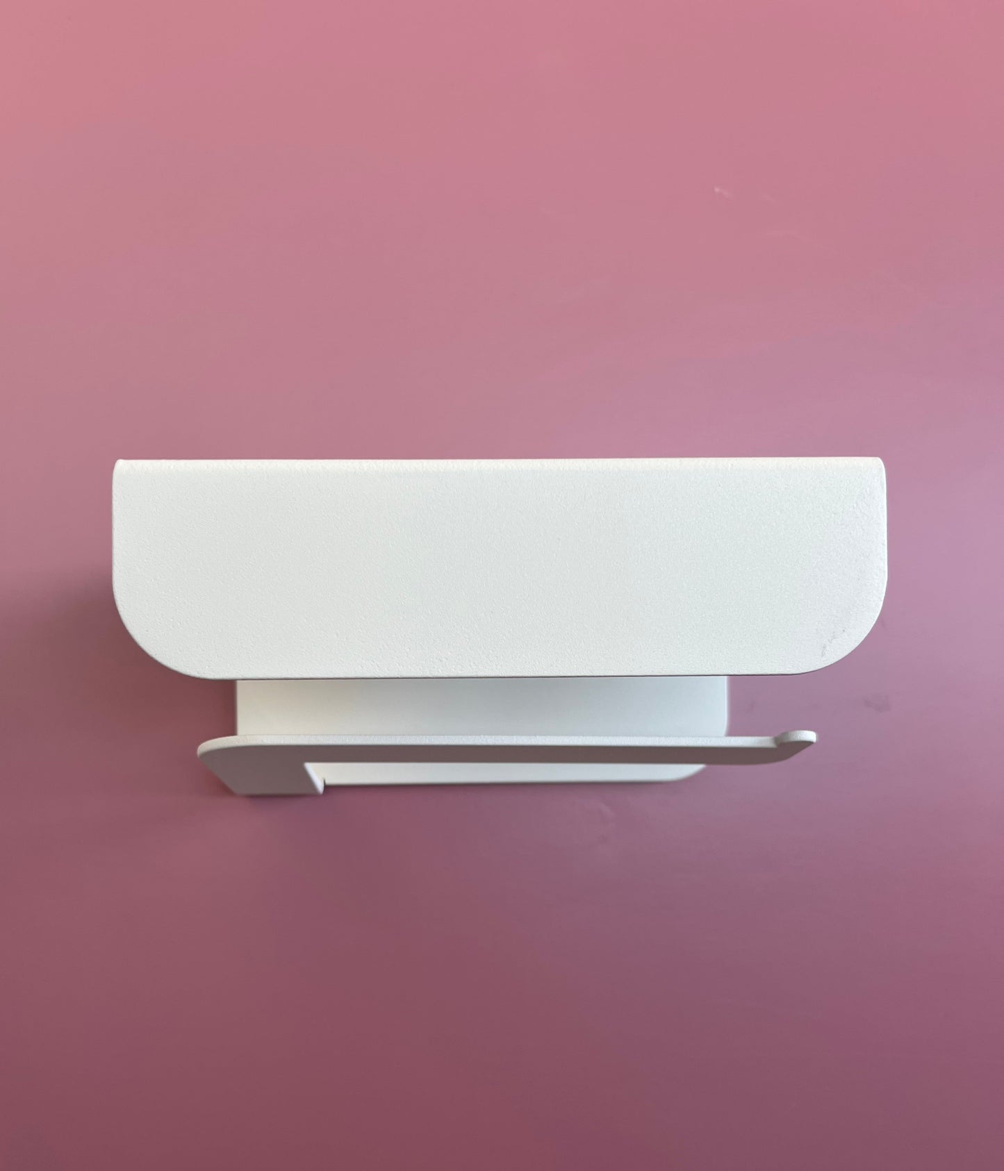 Porte papier toilette crème en aluminium avec un support au dessus 