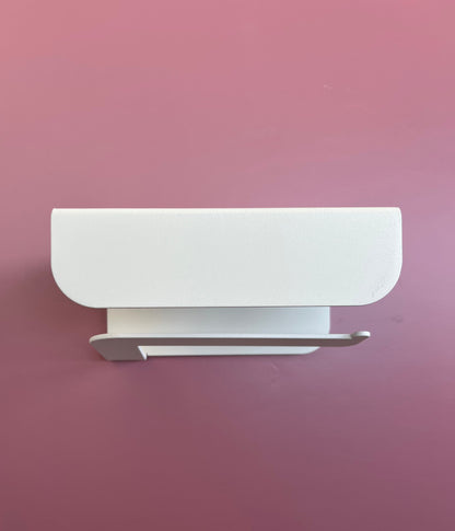 Porte papier toilette crème en aluminium avec un support au dessus 